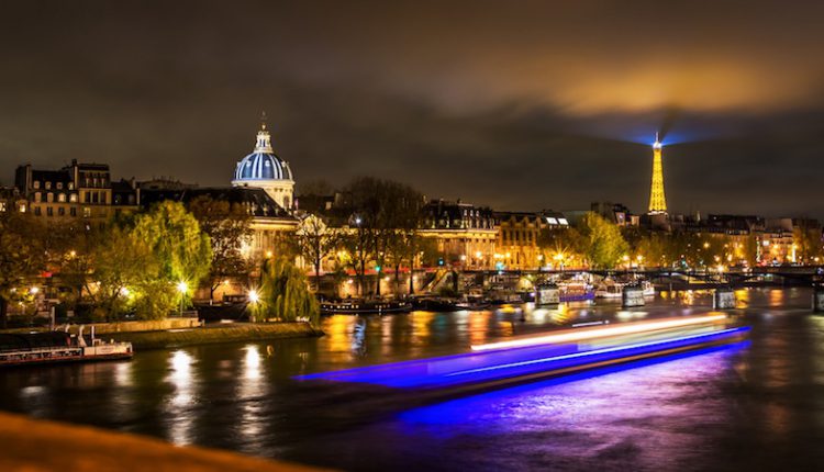 Vue de Paris la nuit avec bateau de croisière dîner sur la Seine